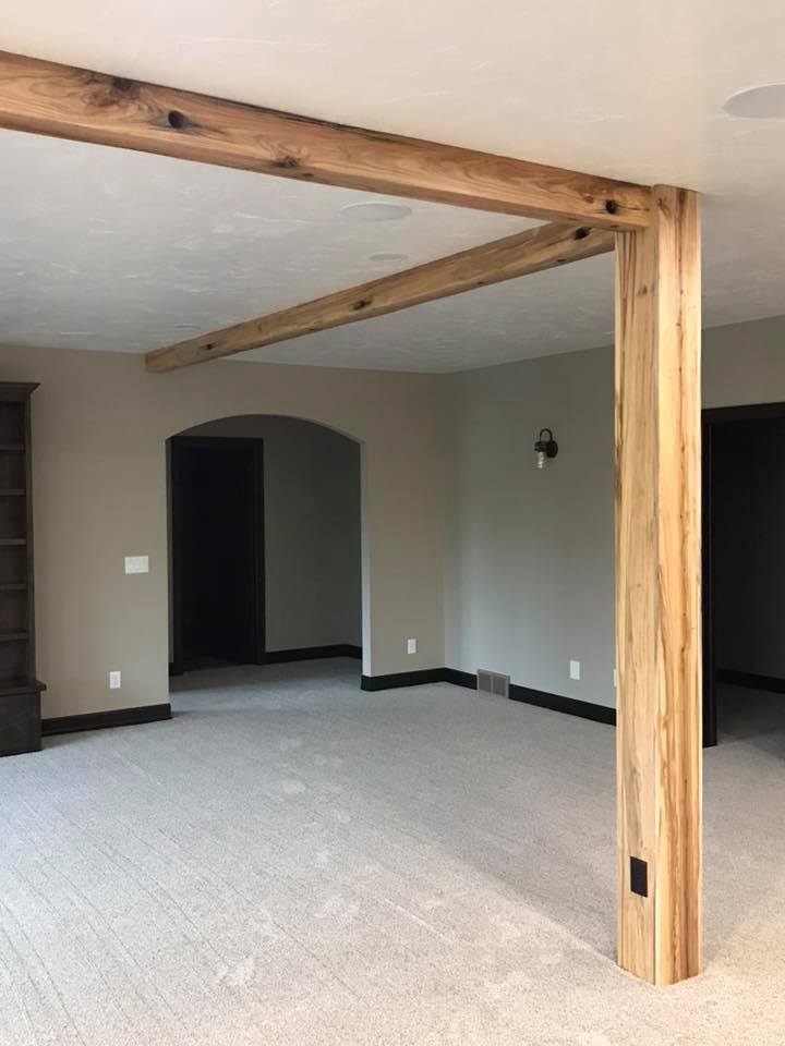 Interior basement walls painted gray with a reclaimed wood support beam and arched doorway, RPS Painting, Sioux Falls SD.