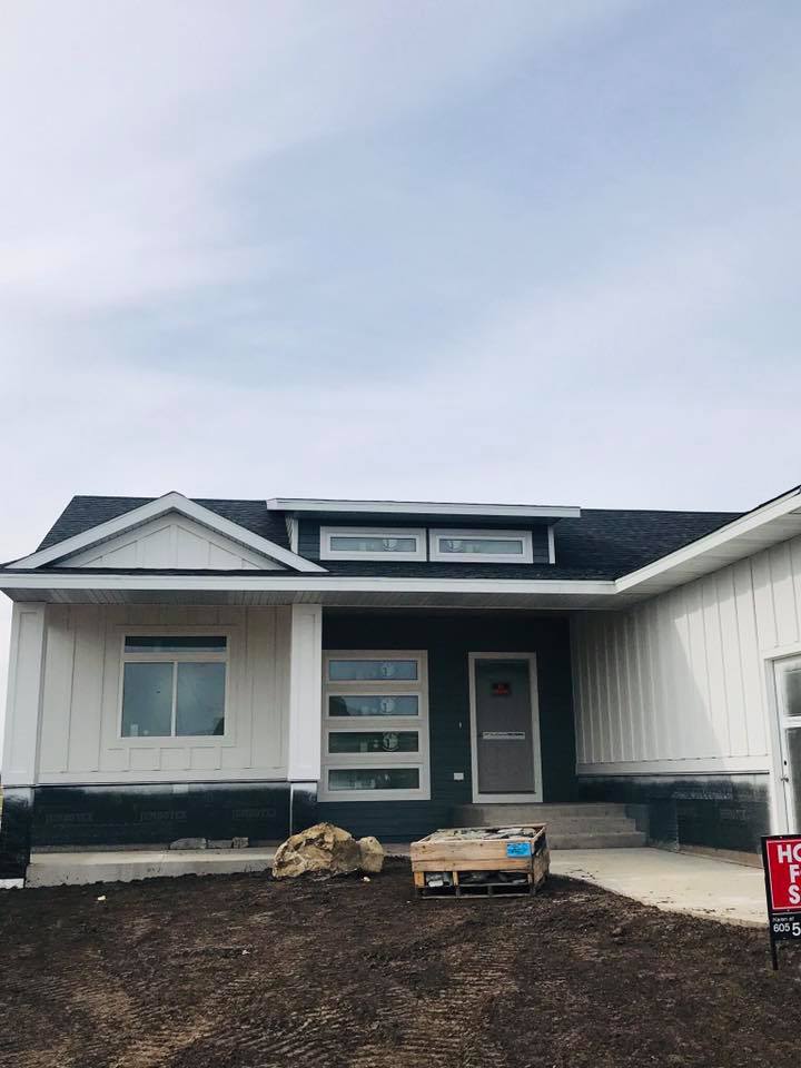 Two-tone exterior repaint with white siding and dark green trim, RPS Painting, Sioux Falls SD.